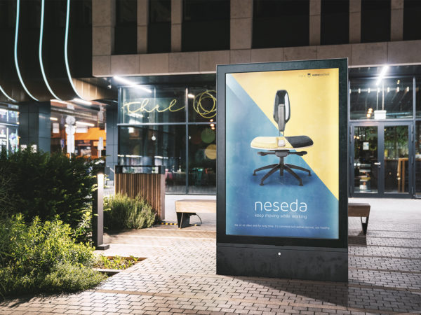 Free urban city light box mockup that helps you showcase your outdoor advertising design in a night city lights. The free PSD mockup file consists of smart objects.
