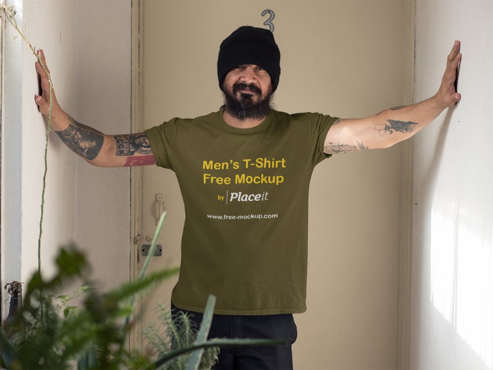 Mockup of a Tattooed Man Wearing a T-Shirt Indoors