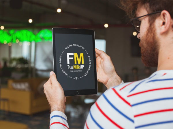 Man Holding an iPad Mockup at a Restaurant