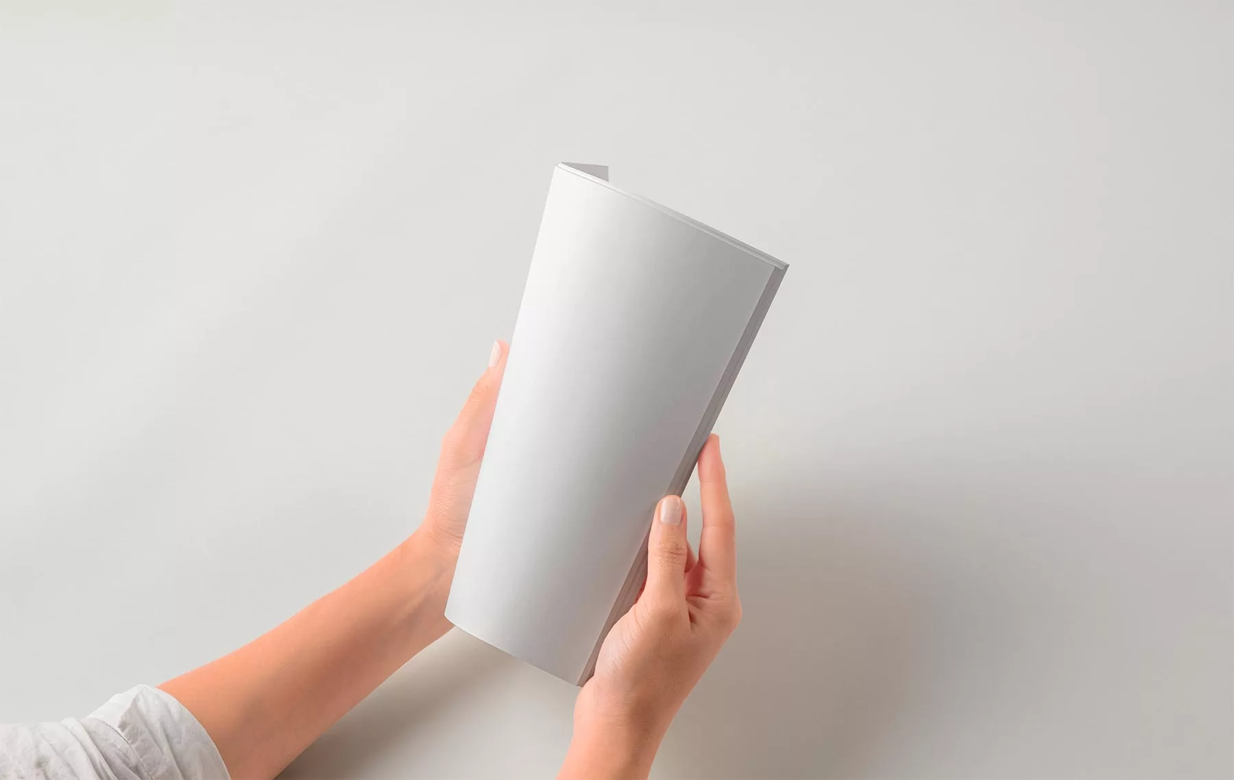 Hands Holding Folded Magazine Mockup