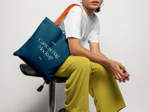 Canvas Bag Mockup (Woman Seated in Studio, Bag on Shoulder)