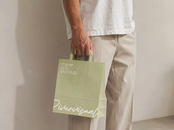 Free Man Holding Paper Shopping Bag Mockup